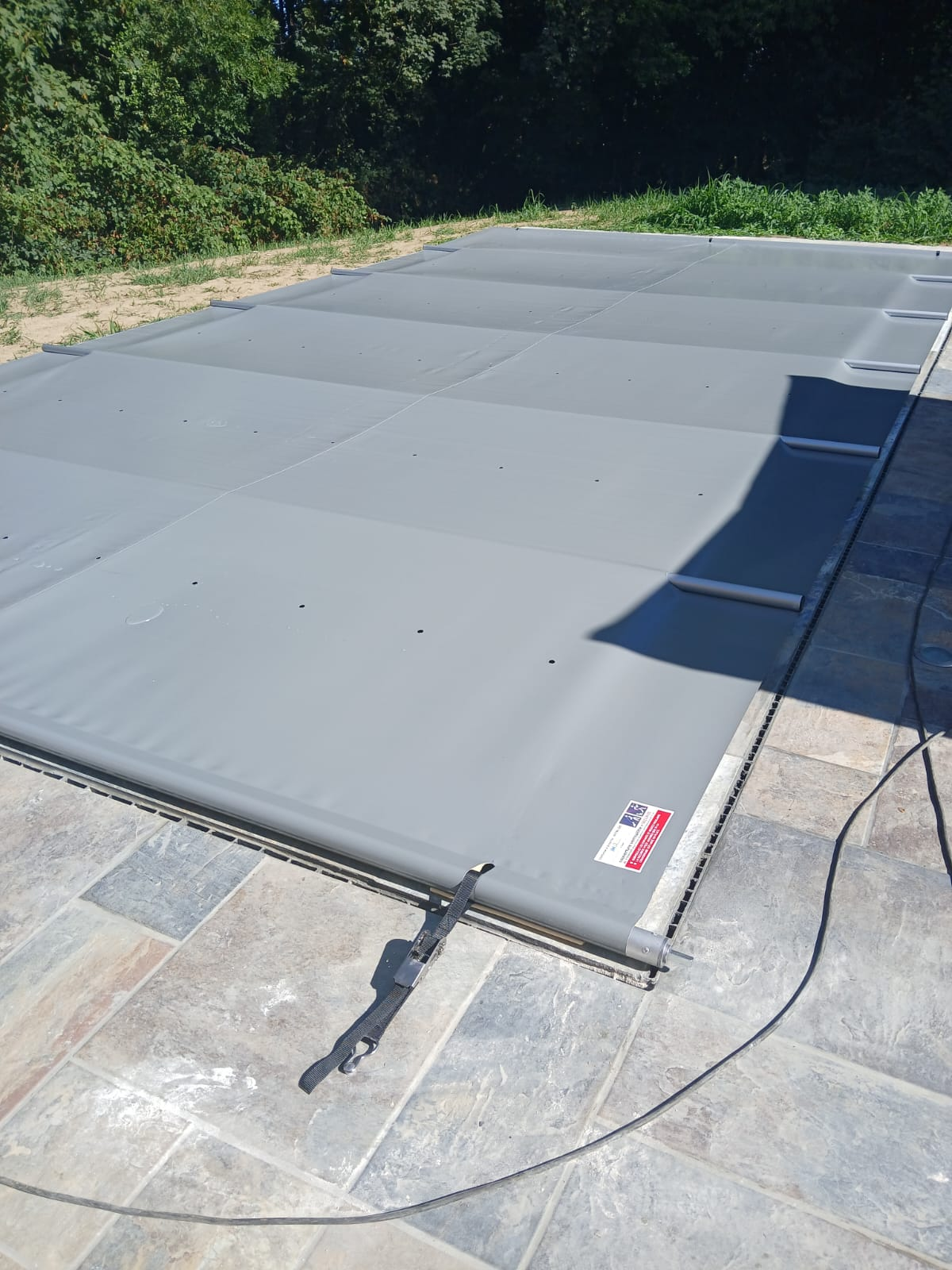 Couverture de sécurité à barres posée sur une piscine